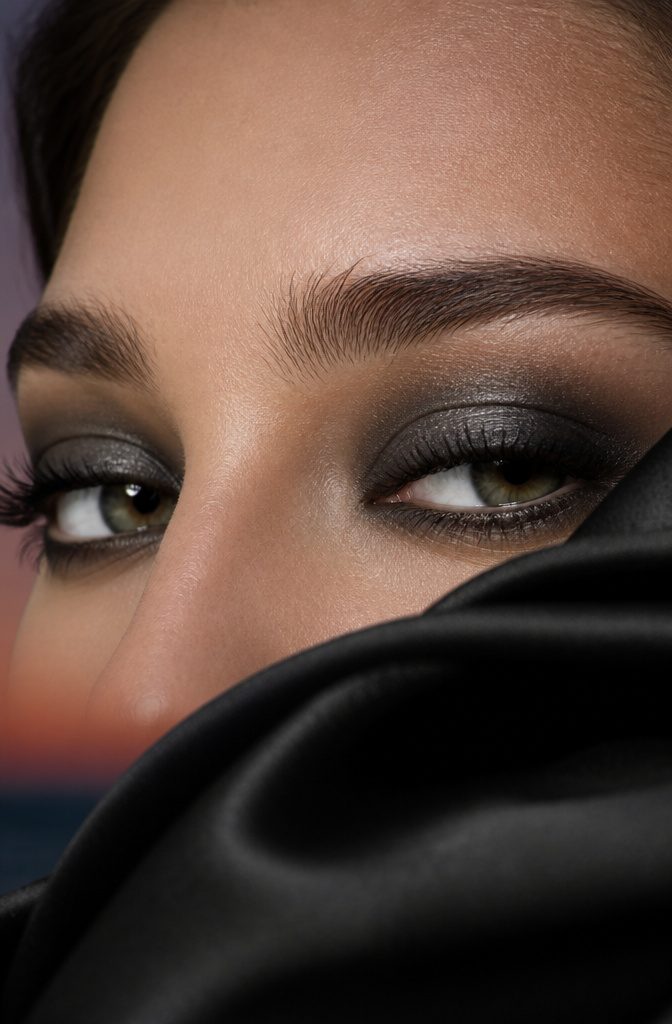 A close-up of a model's eyes with a smoky makeup look.