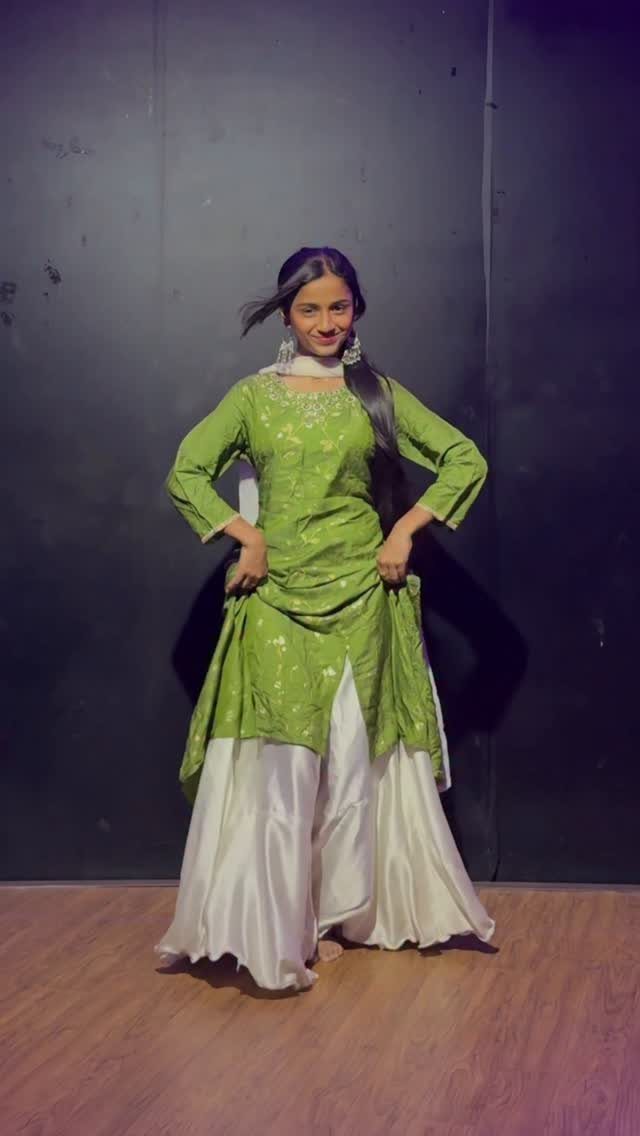 Woman wearing a lime green embroidered tunic and wide white palazzo pants.
