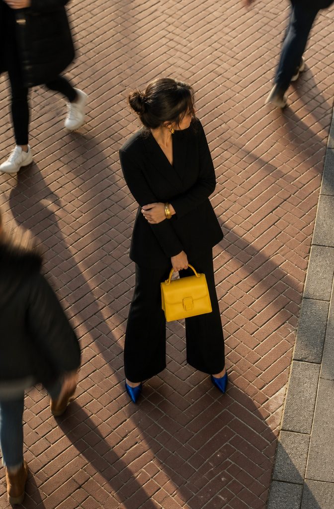 A canary yellow bag and other accessories displayed for styling.