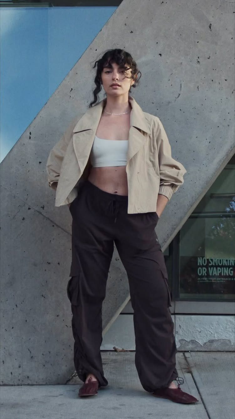 Woman wearing a beige jacket, white tube top, and brown wide-leg cargo pants.