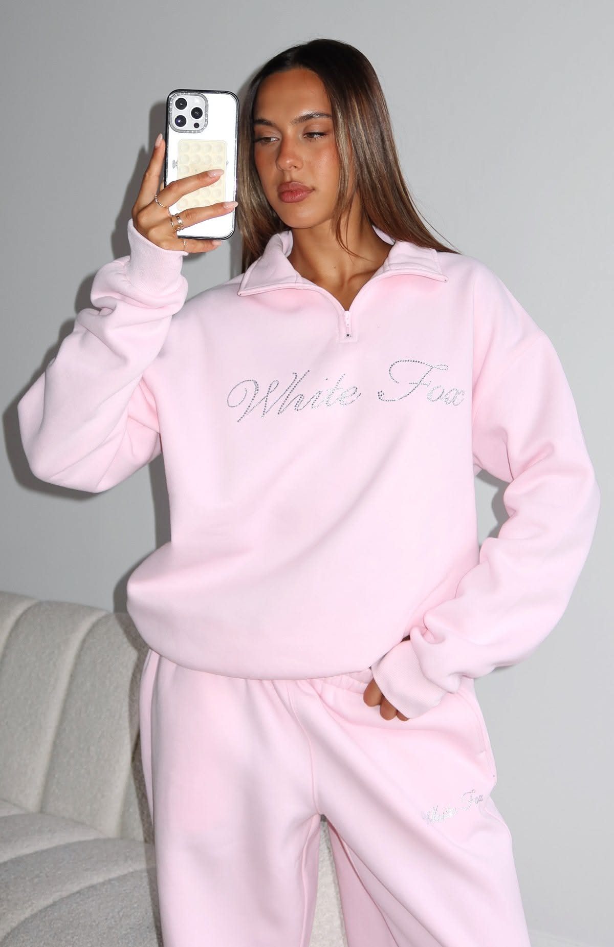 Woman wearing a light pink fleece quarter-zip pullover and matching pink pants.