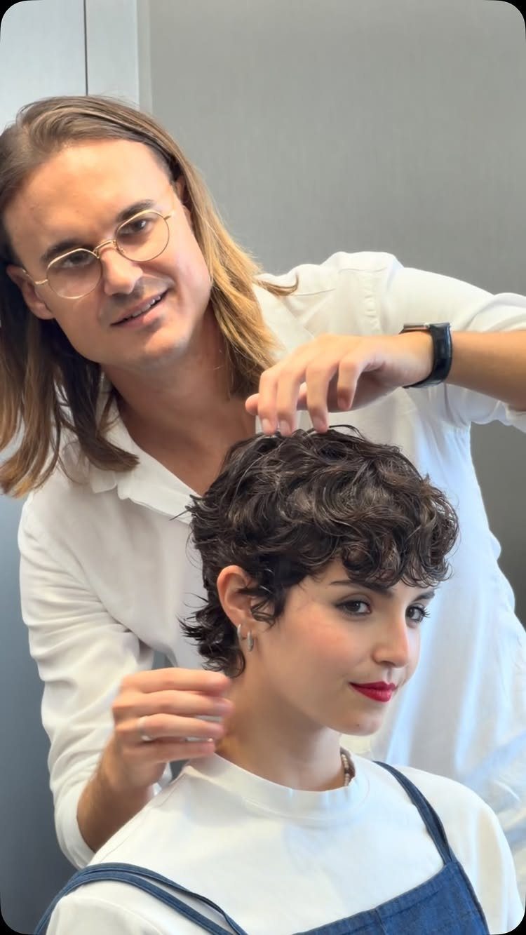 19 Short Pixie Cuts Over 40 With Styling and Color Tips 5 Woman with a short curly pixie cut being styled by a hairdresser.