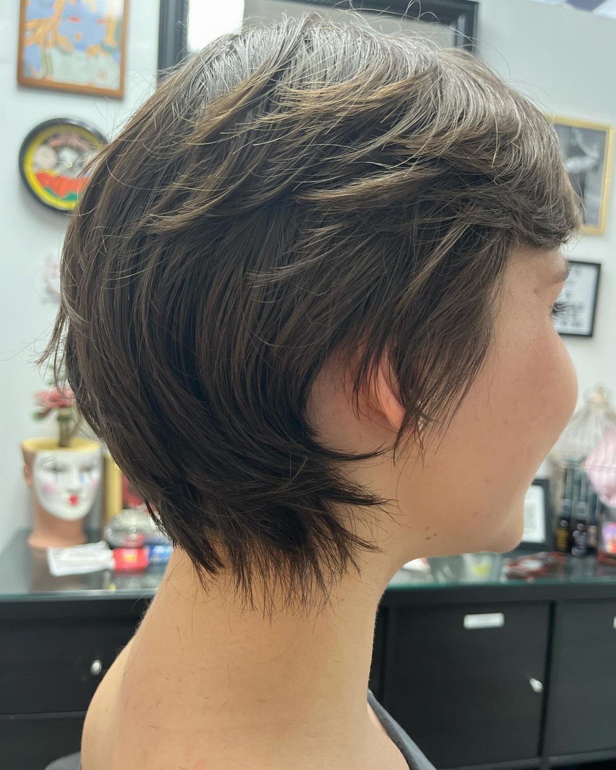 19 Short Pixie Cuts Over 40 With Styling and Color Tips 6 Short brown pixie haircut with soft, feathered layers seen from a side profile.