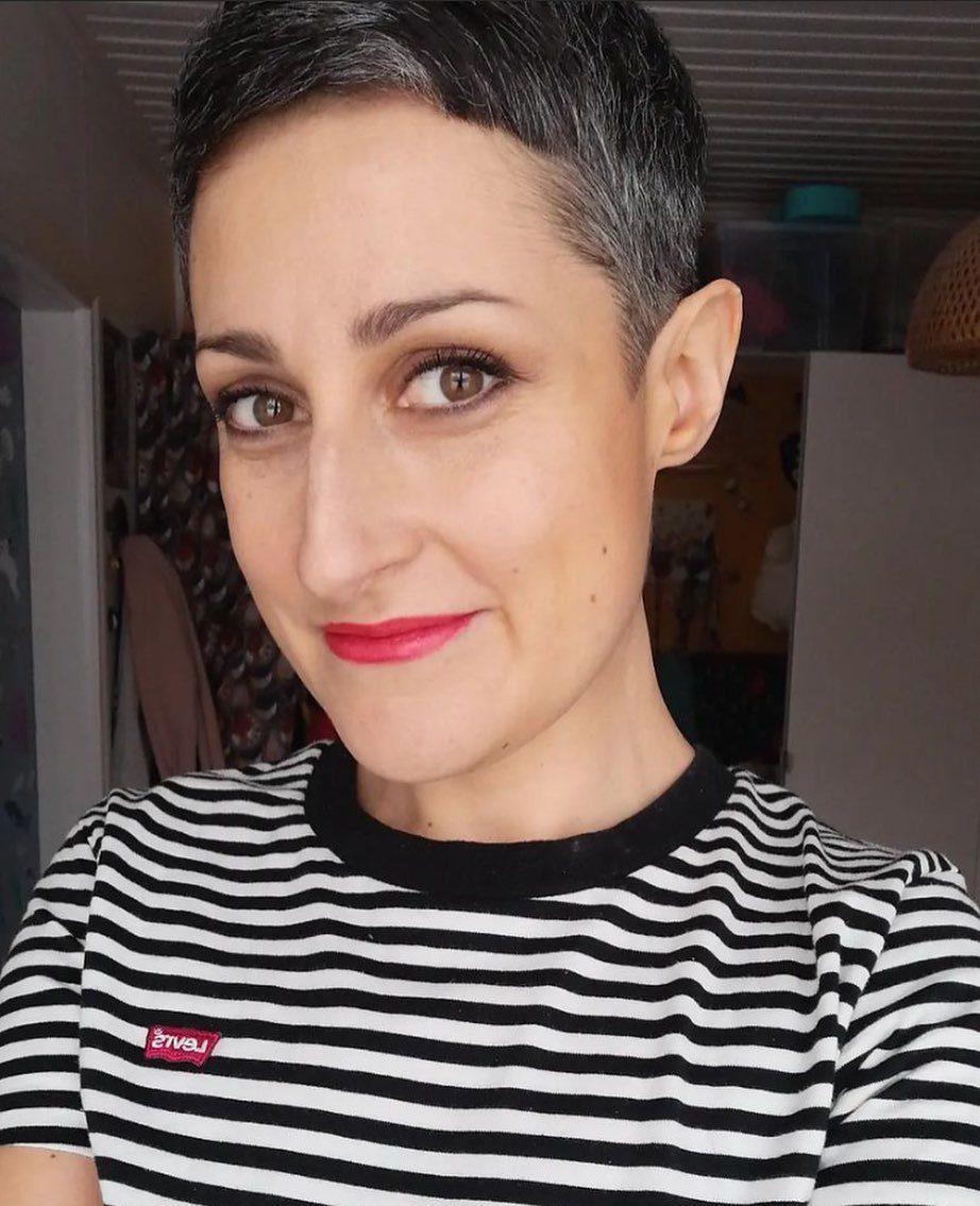 19 Short Pixie Cuts Over 40 With Styling and Color Tips 16 Woman with a short salt-and-pepper pixie haircut wearing a striped t-shirt.