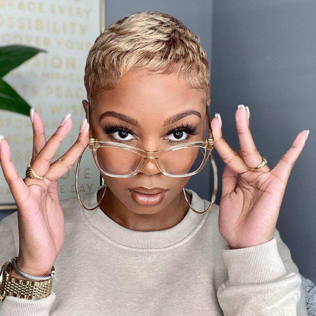 19 Short Pixie Cuts Over 40 With Styling and Color Tips 8 Woman with a sculpted ash blonde crop haircut wearing clear glasses and beige sweater.