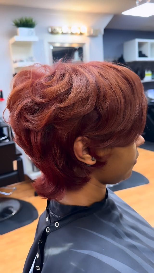 19 Short Pixie Cuts Over 40 With Styling and Color Tips 14 Reddish-brown shaggy bixie haircut with voluminous layers on a person in a salon.