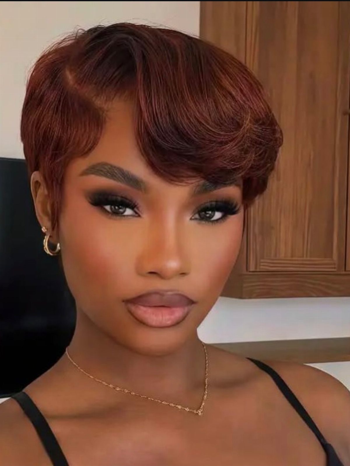 19 Short Pixie Cuts Over 40 With Styling and Color Tips 12 Woman with a sleek reddish-brown side-part pixie cut and polished curved bangs.