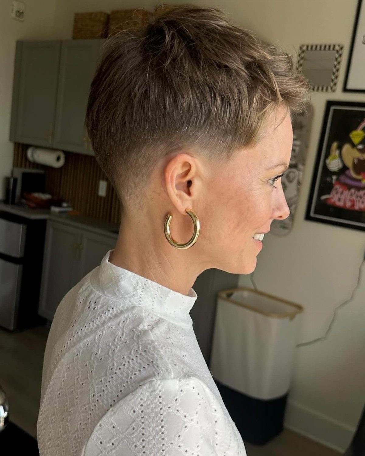 19 Short Pixie Cuts Over 40 With Styling and Color Tips 7 Woman with a soft textured tapered pixie haircut and gold hoop earrings.