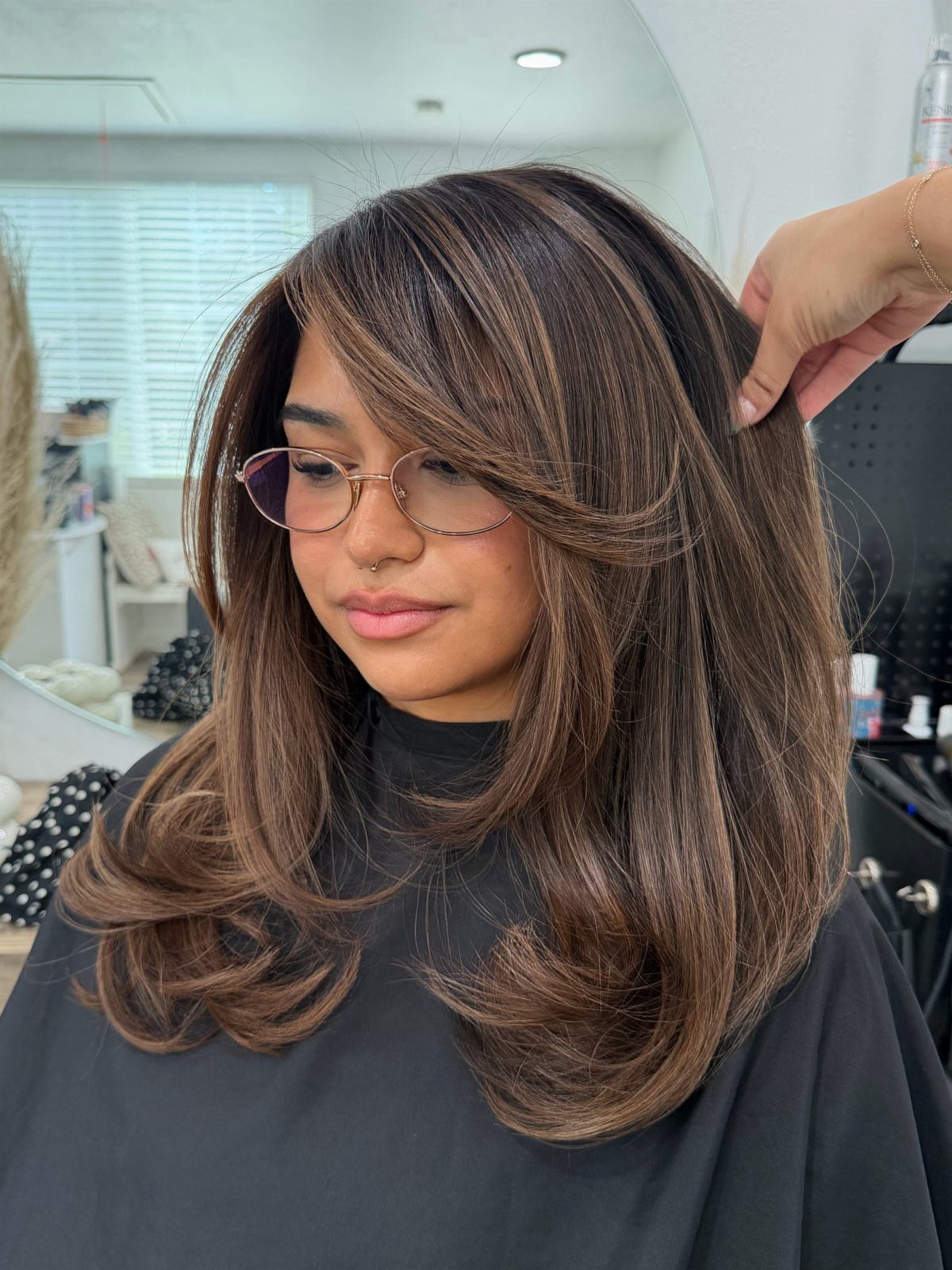 16 Shoulder Length Layered Hair Ideas for Every Texture 12 Woman with shoulder-length brown hair featuring balayage highlights and voluminous layered cuts.