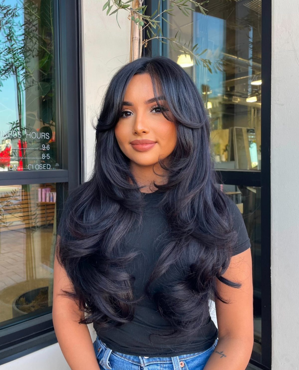 16 Shoulder Length Layered Hair Ideas for Every Texture 6 Woman with voluminous black shoulder-length hair featuring soft face-framing layers and waves.